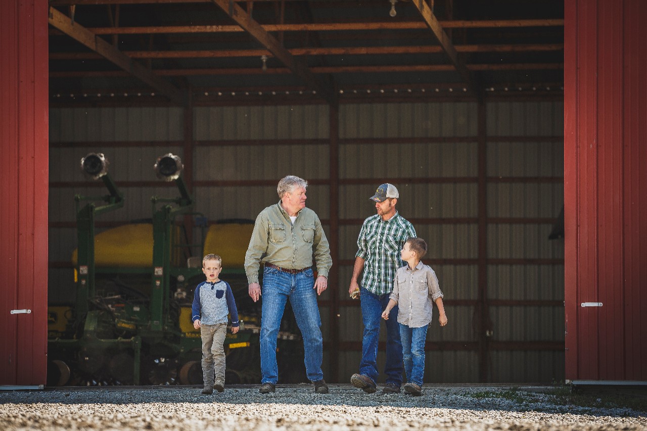 Farm family standing in front of tool shed