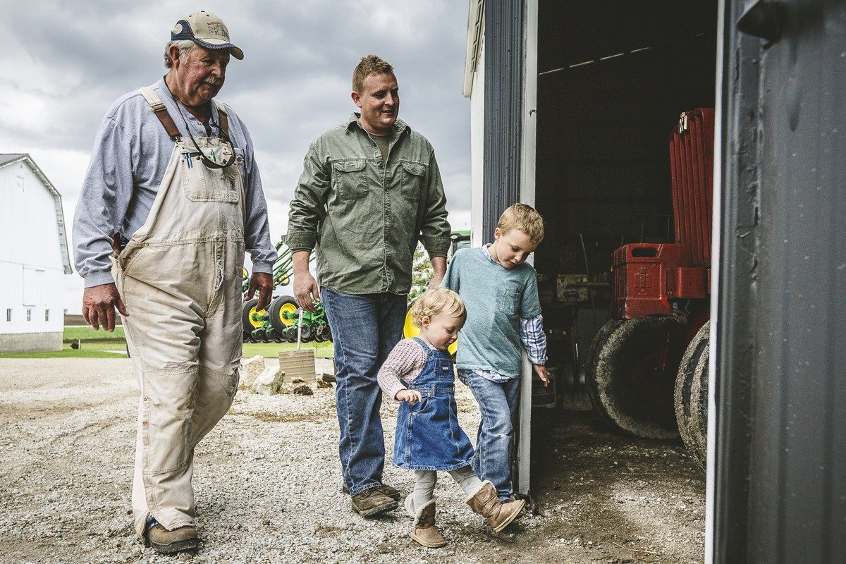 Family with grandfather walking into barn
